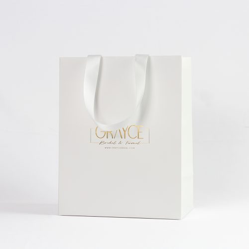 Elegant white bridal paper bag with gold foil logo and satin ribbon handles, designed for wedding boutiques and luxury gift packaging