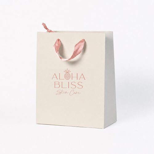 Custom ivory skincare paper bag with rose gold logo foil stamping and blush pink ribbon handles